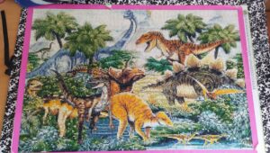 Toile en Diamand Painting représentant plusieurs espèces de dinosaures